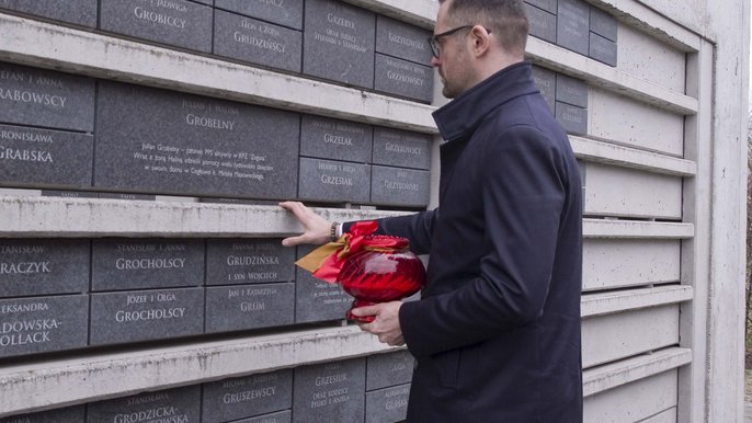Dyrektor Pawel Bliźniuk zapala znicz przed tabliczką Juliana Grobelnego. Dyrektor Pawel Bliźniuk zapala znicz przed tabliczką Juliana Grobelnego.