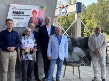 wspólne zdjęcie pod tablicą zaproszonych i przemawiających gości