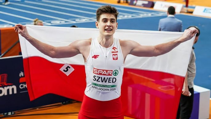 - Maksymilian Szwed pozujący do zdjęcia z Polską flagą