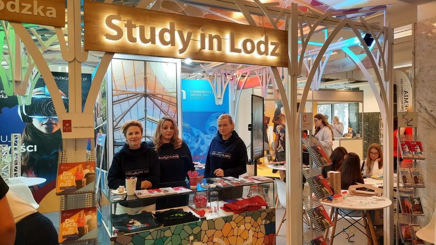 Stoisko pod hasłem "study in Lodz". Trzy kobiety w ciemnych bluzach.